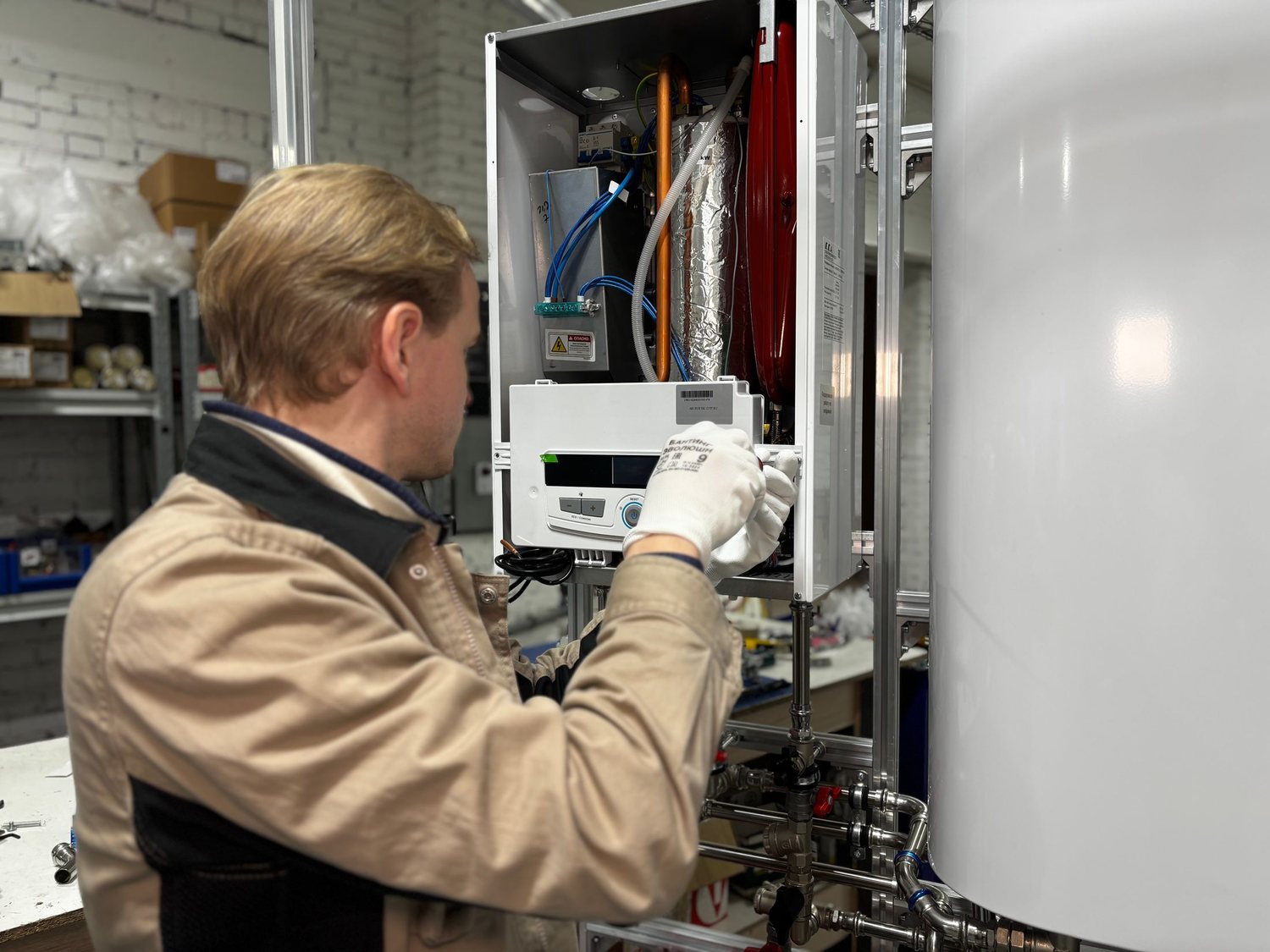 A heating engineer working on a wall-hung boiler