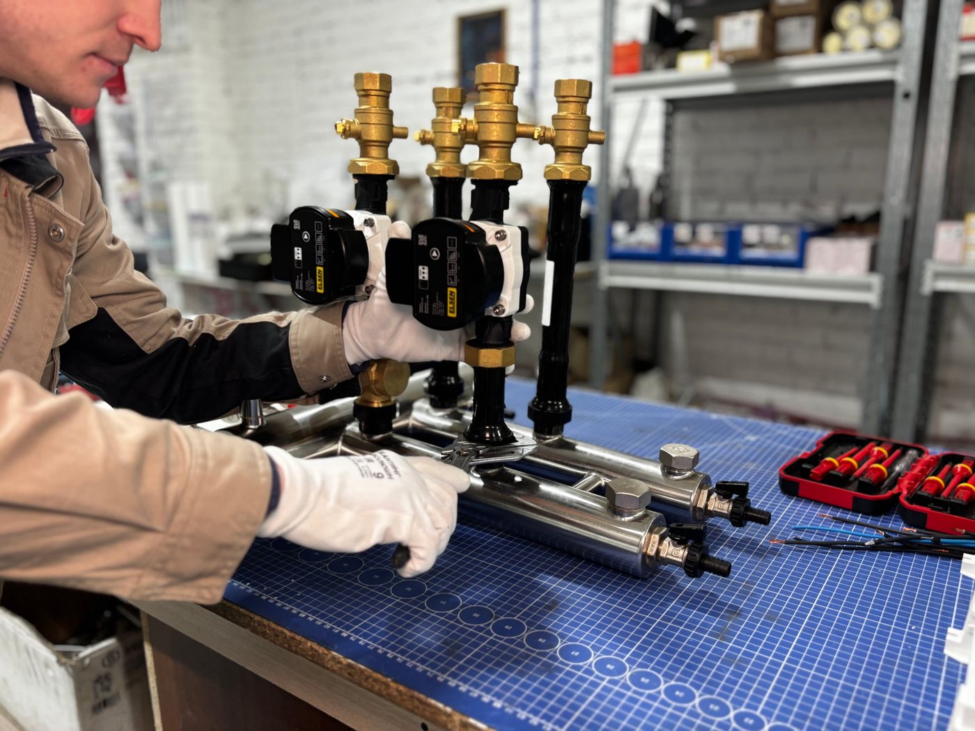 An engineer assembling heating manifold valves