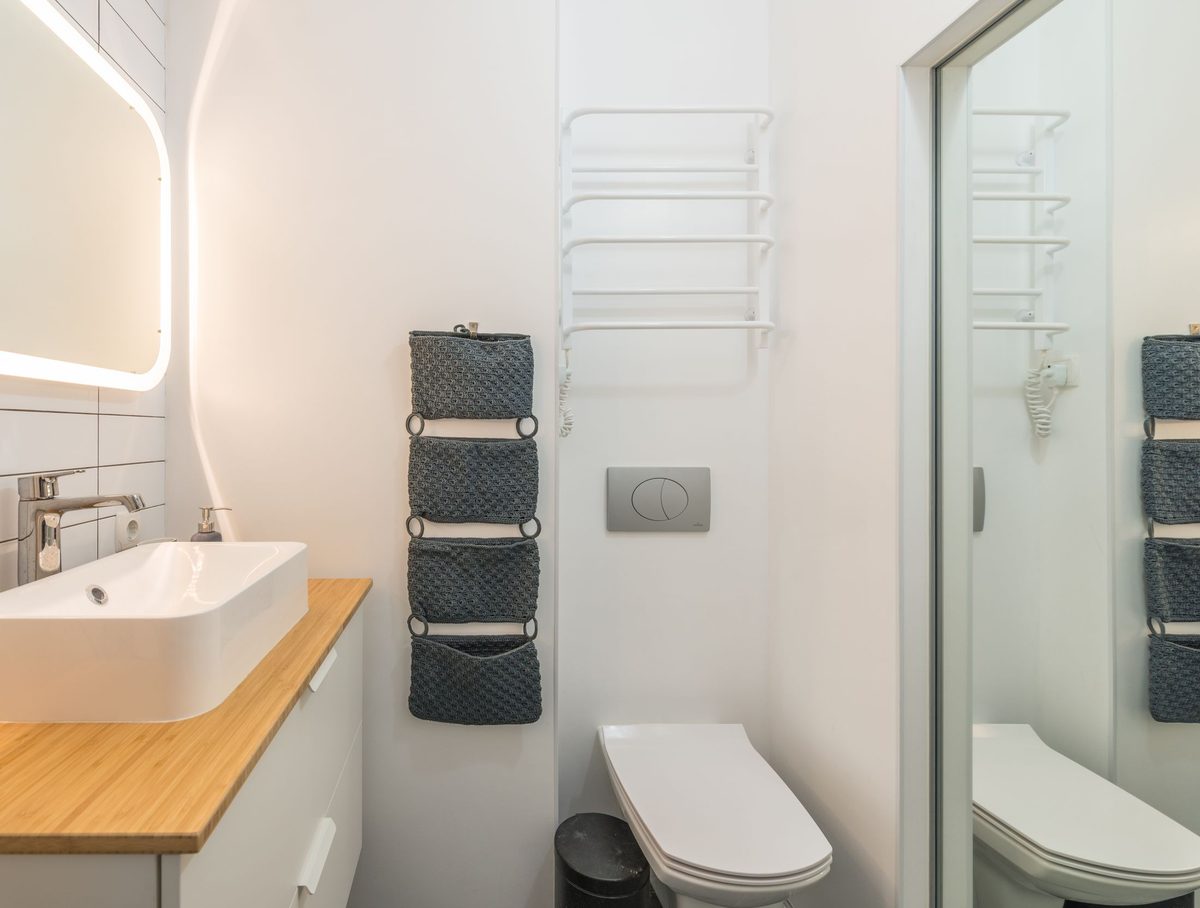 A compact modern bathroom: counter-top basin on a timber shelf, concealed-cistern WC and a towel radiator, planned so a small room still works properly.