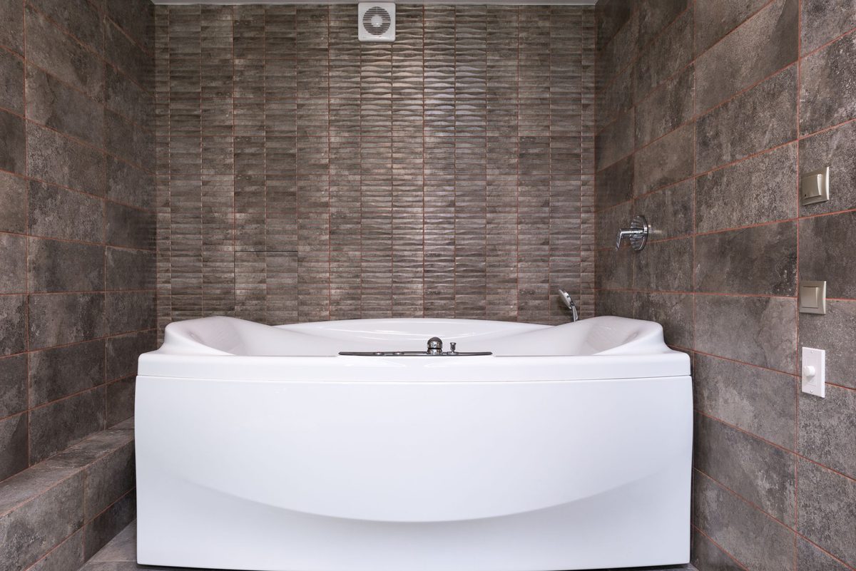 A bath with a tiled surround and a concealed shower valve — a typical family bathroom refit from strip-out to final test.